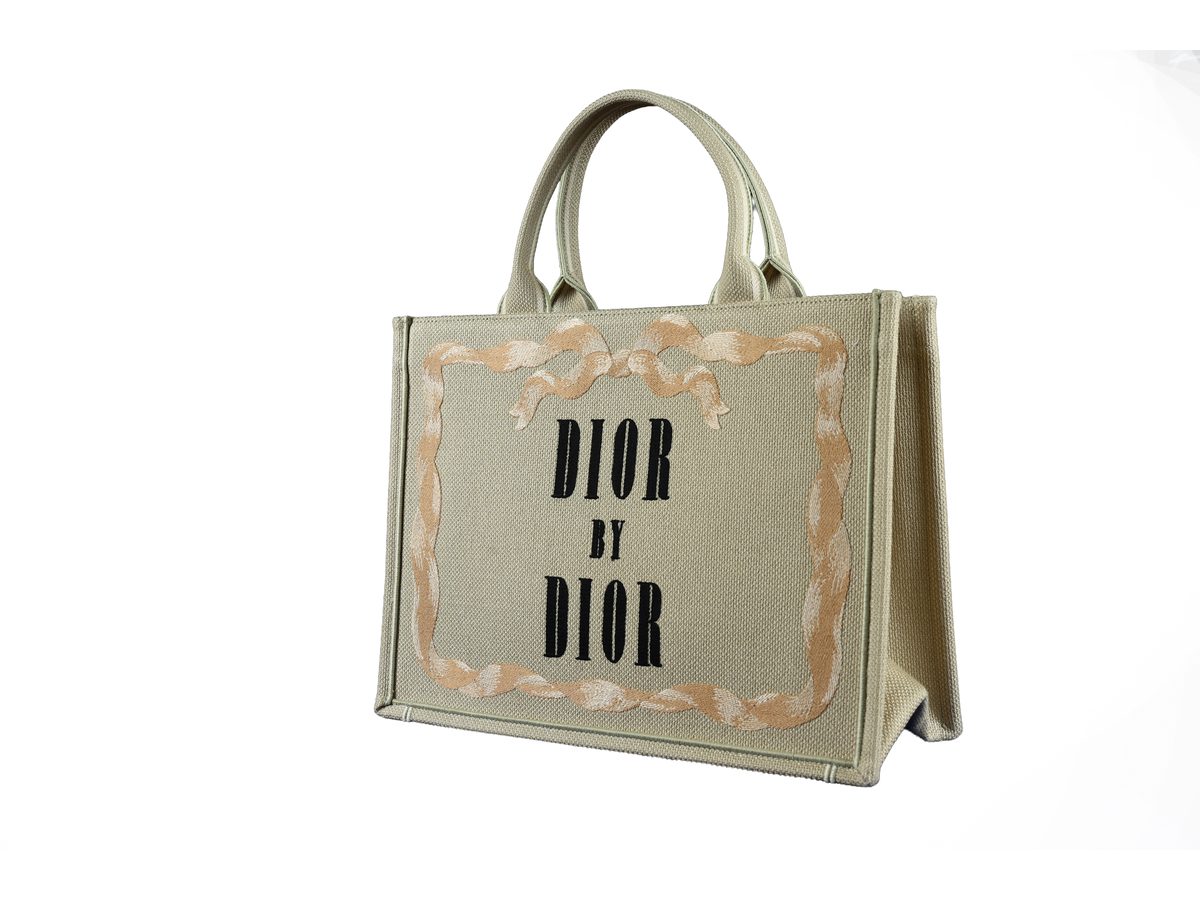 Sac Dior Book Tote Medium en toile beige écru vu de trois quarts, sur fond blanc