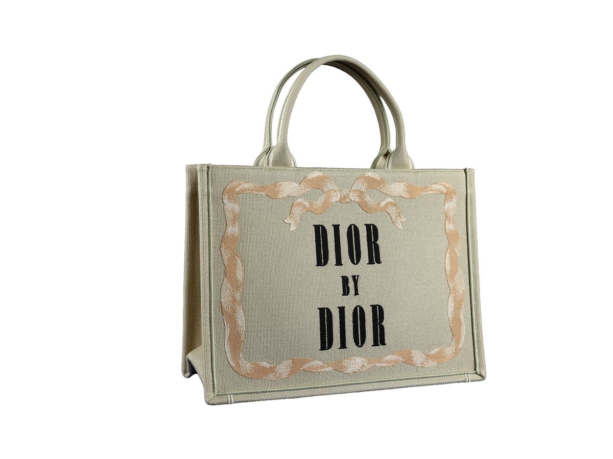 Sac Dior Book Tote Medium en toile beige écru vu de côté, sur fond blanc
